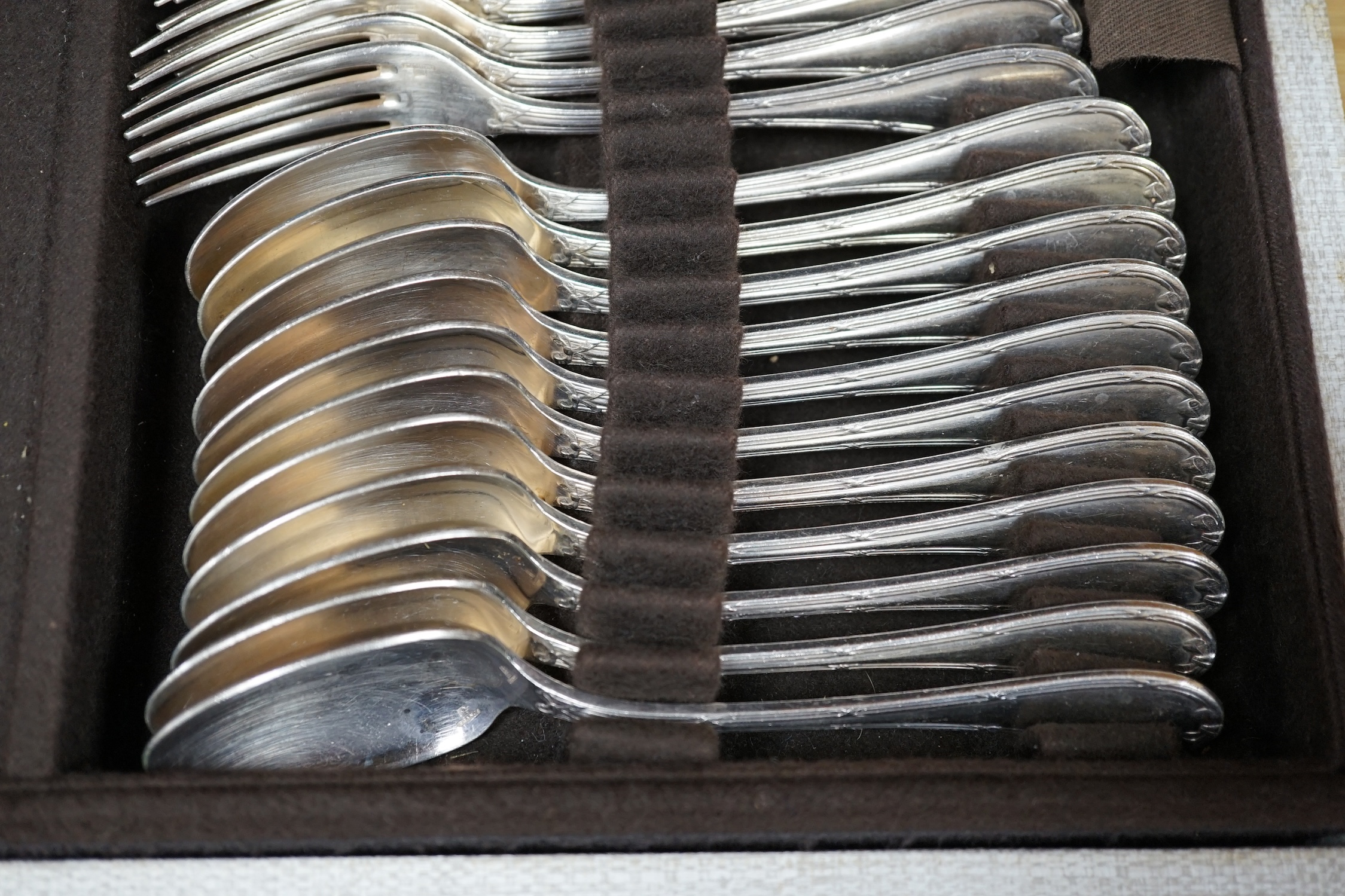 A cased canteen of French Christofle silver plated bow pattern cutlery, a twelve piece setting contained within two layers, case 49.5cm wide, 31cm deep, 13.5cm high